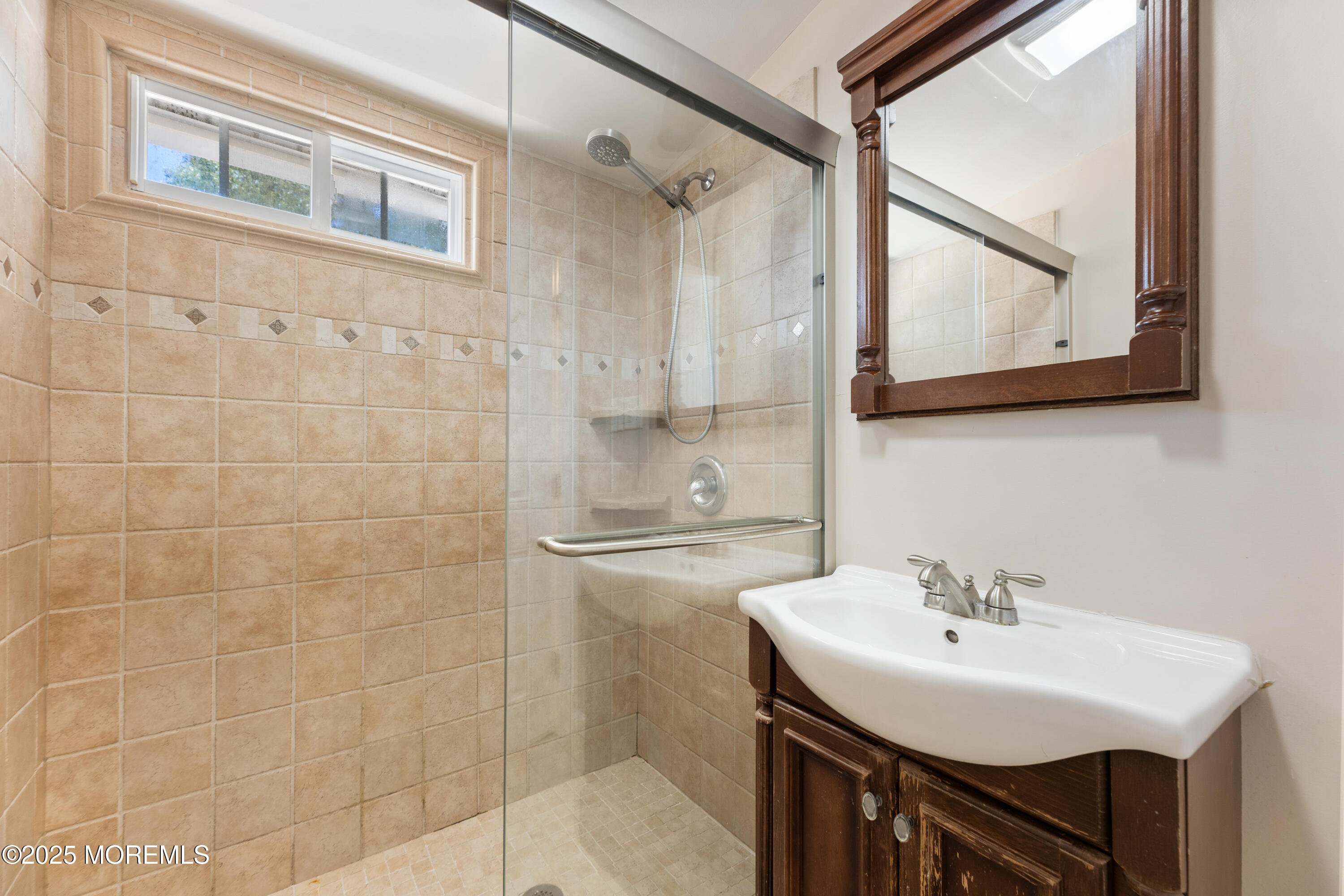 474 Burnt Bark Road Brick, NJ 08723 - Photo 18 of 28 a bathroom with a sink a mirror and a shower