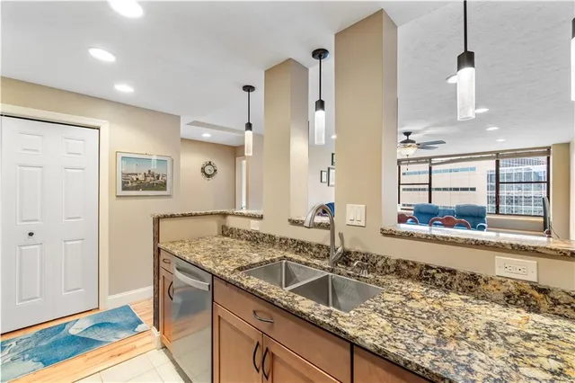 a kitchen with granite countertop a sink and a refrigerator