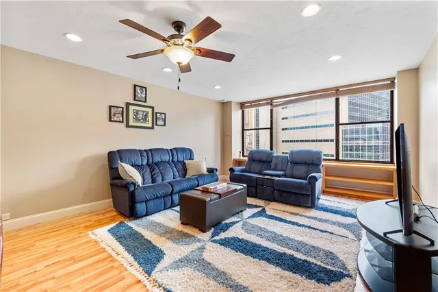 a living room with furniture ceiling fan and a rug