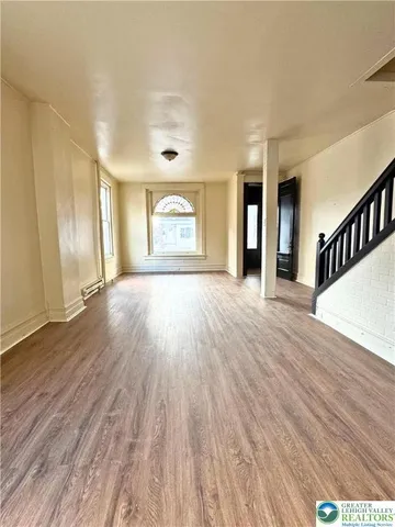 a view of a room with wooden floor and window
