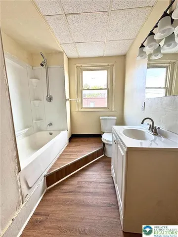 a bathroom with a tub a sink and a large mirror