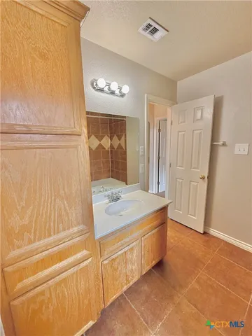 a bathroom with a granite countertop sink and a mirror