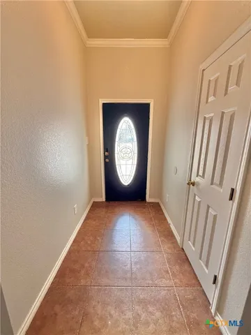 a view of a hallway with brick walls and a window