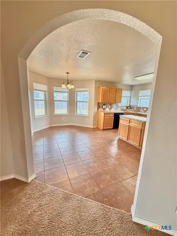 a view of a refrigerator in kitchen and a window