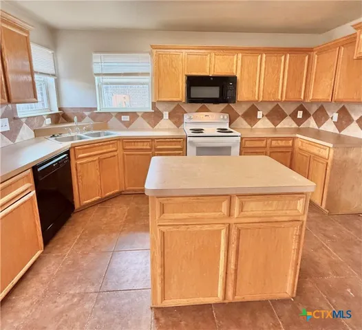 a kitchen with a sink and a stove top oven