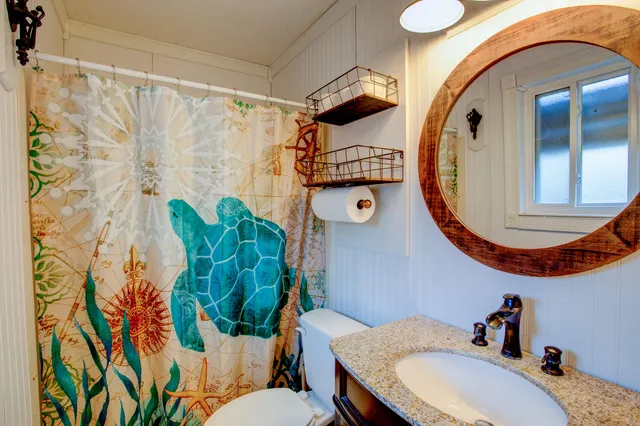 a bathroom with a sink and mirror with toilet