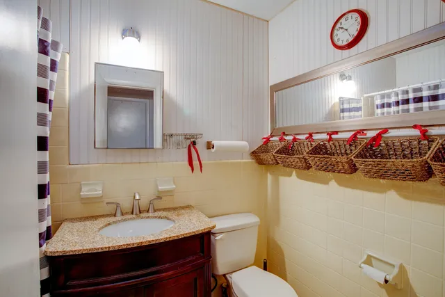 a bathroom with a granite countertop sink a toilet and a mirror