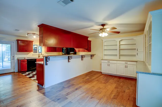 a kitchen with stainless steel appliances granite countertop a stove top oven a sink with wooden floors