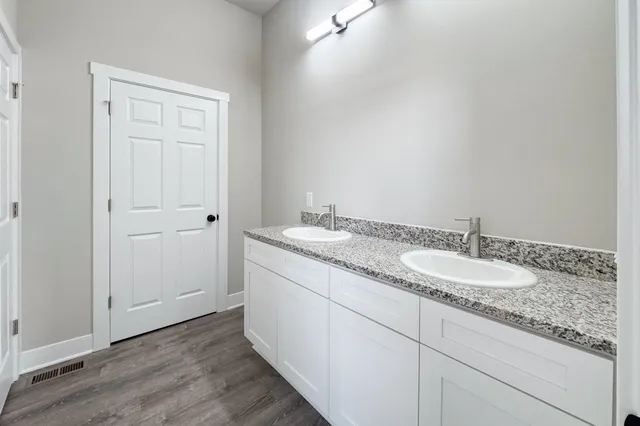 a bathroom with a granite countertop sink and a mirror