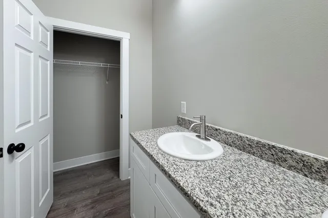 a bathroom with a granite countertop sink and a mirror