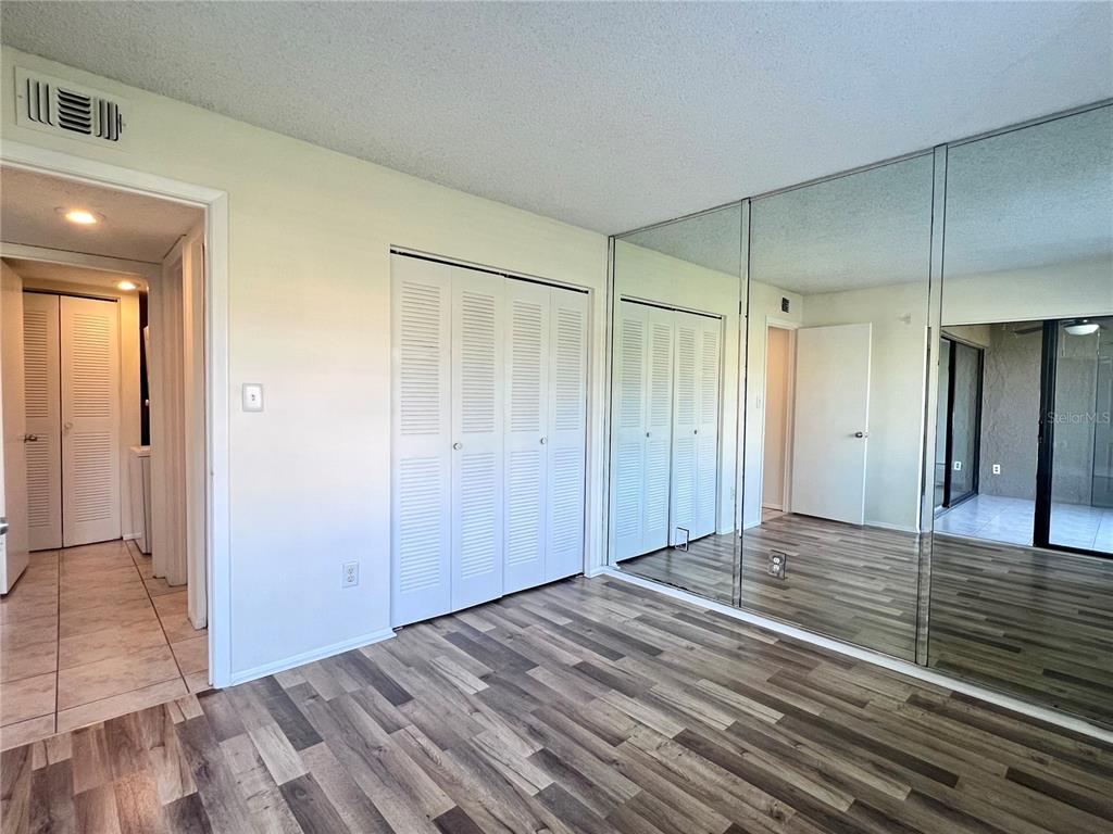 3233 Candle Ridge Drive, Unit 101 Orlando, FL 32822 - Photo 13 of 24 a view of an empty room with wooden floor and a bathroom