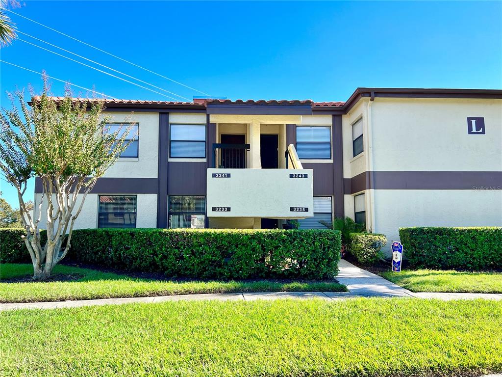 3233 Candle Ridge Drive, Unit 101 Orlando, FL 32822 - Photo 2 of 24 a front view of a house with a yard and garage