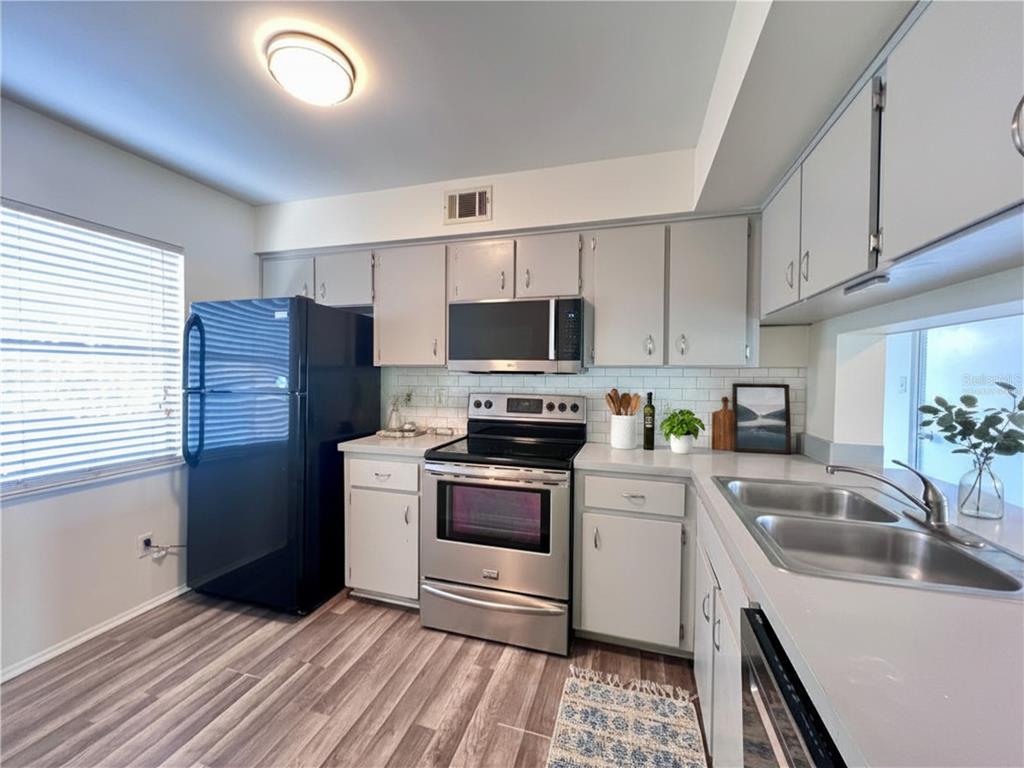 3233 Candle Ridge Drive, Unit 101 Orlando, FL 32822 - Photo 7 of 24 a kitchen with a sink stove and refrigerator
