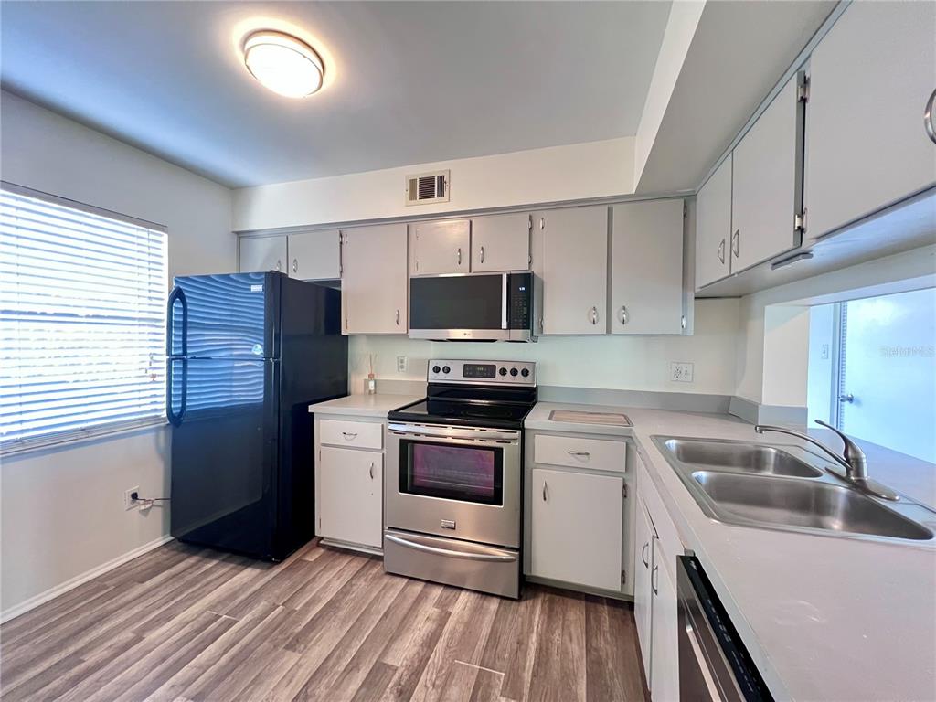 3233 Candle Ridge Drive, Unit 101 Orlando, FL 32822 - Photo 8 of 24 a kitchen with a sink stove and refrigerator