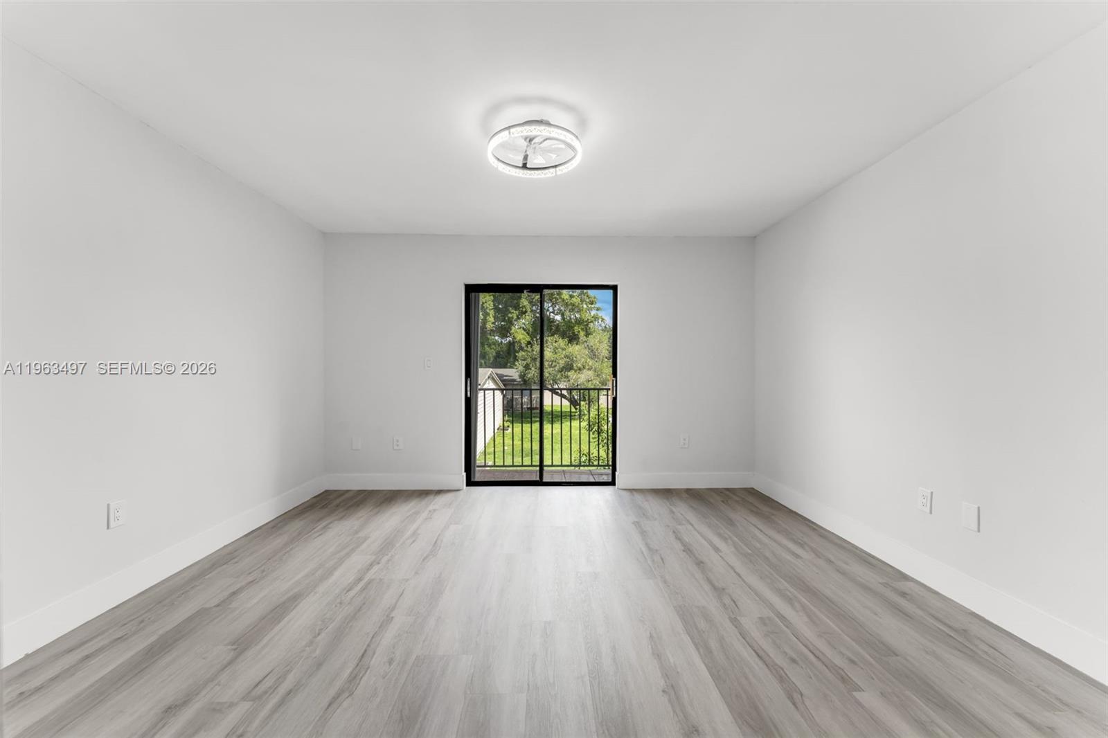 15430 Southwest 74th Cir Court Miami, FL 33193 - Photo 16 of 38 an empty room with wooden floor and windows