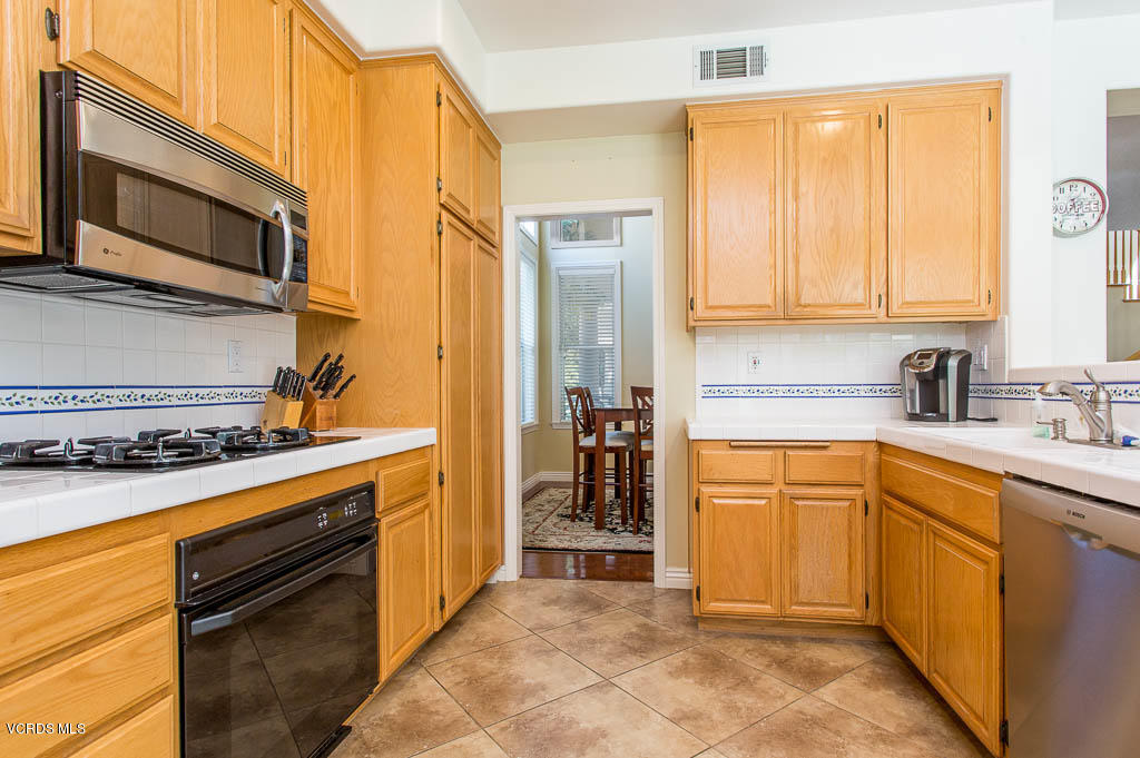 3877 Sunsetridge Road Moorpark, CA 93021 - Photo 11 of 30 a kitchen with stainless steel appliances granite countertop a stove sink and cabinets