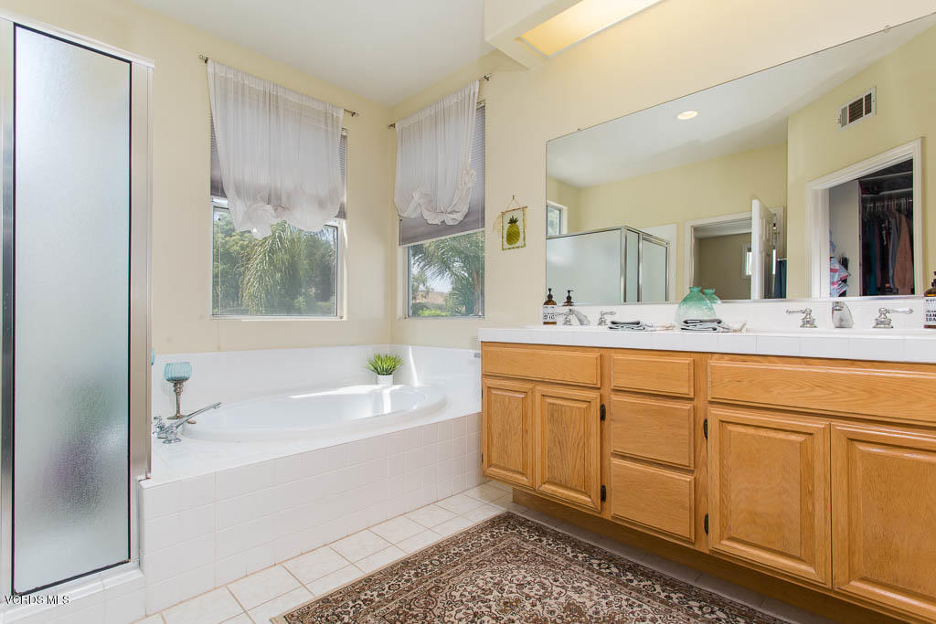 3877 Sunsetridge Road Moorpark, CA 93021 - Photo 16 of 30 a bathroom with a tub sink and mirror