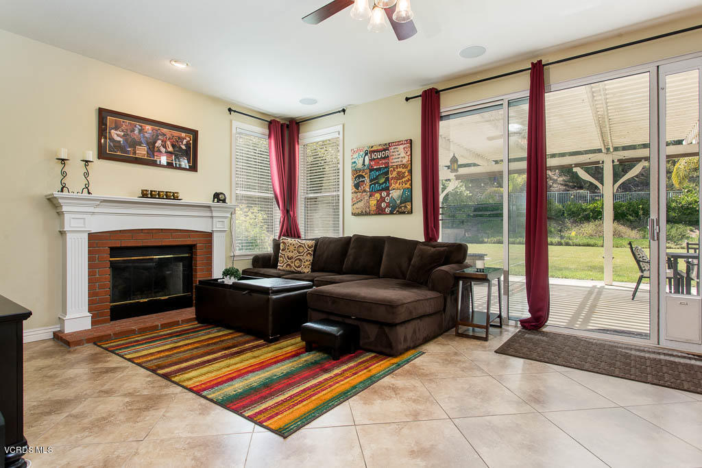 3877 Sunsetridge Road Moorpark, CA 93021 - Photo 8 of 30 a living room with furniture a flat screen tv and a fireplace