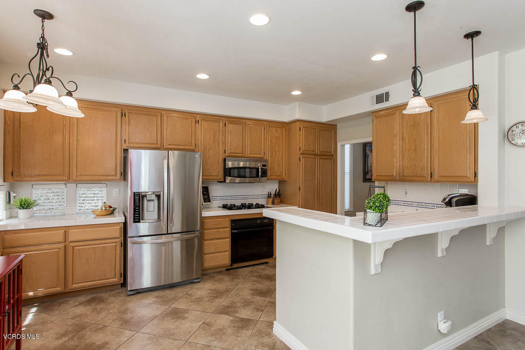 3877 Sunsetridge Road Moorpark, CA 93021 - Photo 10 of 30 a kitchen with kitchen island a sink stainless steel appliances and cabinets