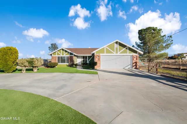a view of an house with backyard space and parking