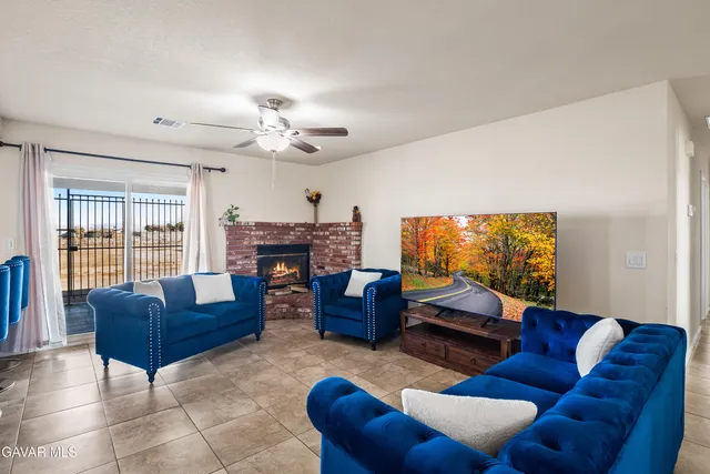 a living room with furniture a fireplace and a large window