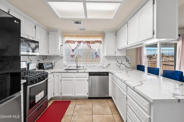 a kitchen with a sink stove top oven and cabinets