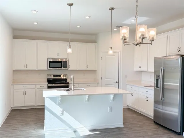 a kitchen with a sink a stove and a wooden floors
