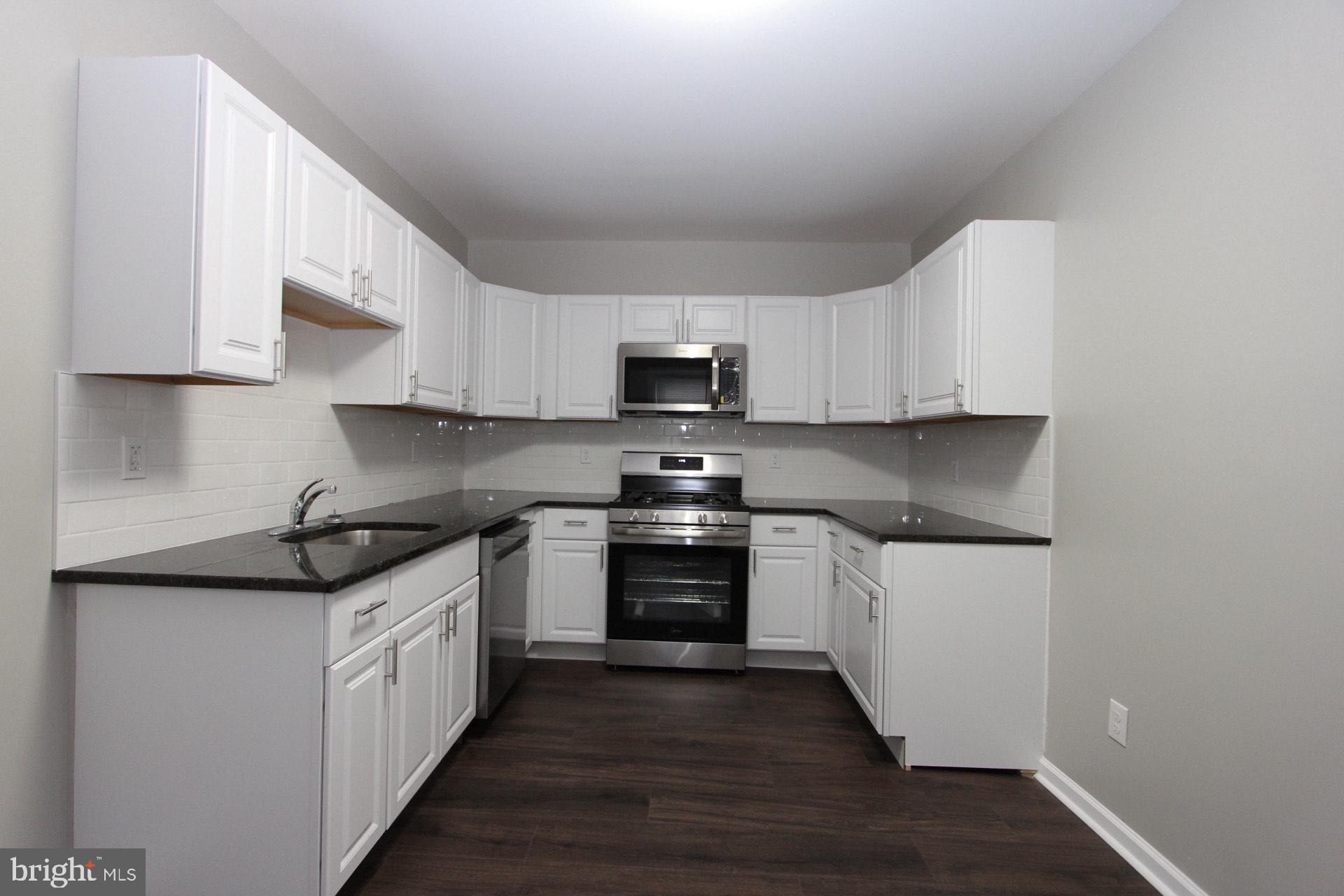 717 Hunter Street Gloucester City, NJ 08030 - Photo 13 of 31 a kitchen with stainless steel appliances granite countertop a stove and a sink