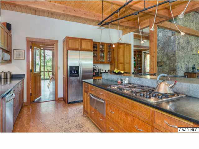 Behind the dining room is the kitchen with custom cherry cabinetry and a massive concrete island.