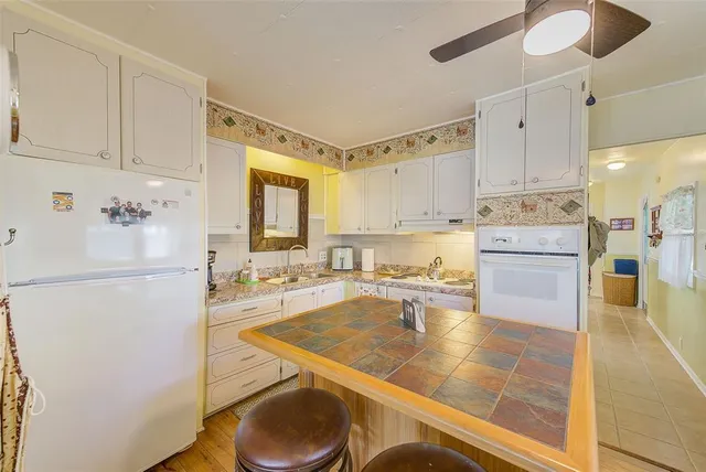a large kitchen with kitchen island a large counter space stainless steel appliances and cabinets