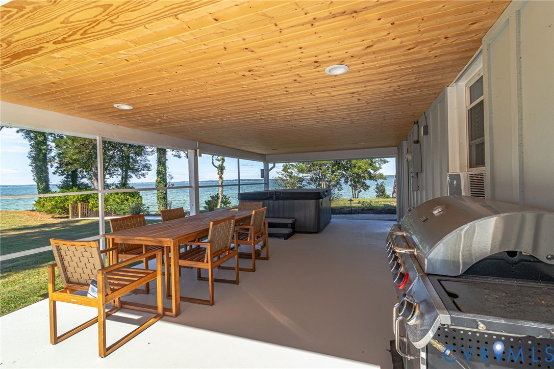 560 Eubank Landing Road Topping, VA 23169 - Photo 18 of 50 a view of a patio with chairs and floor to ceiling window