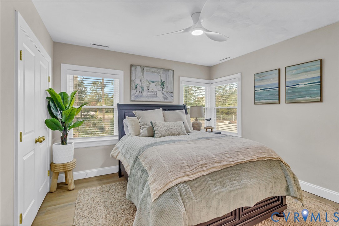 560 Eubank Landing Road Topping, VA 23169 - Photo 35 of 50 a bedroom with a large bed and a chandelier