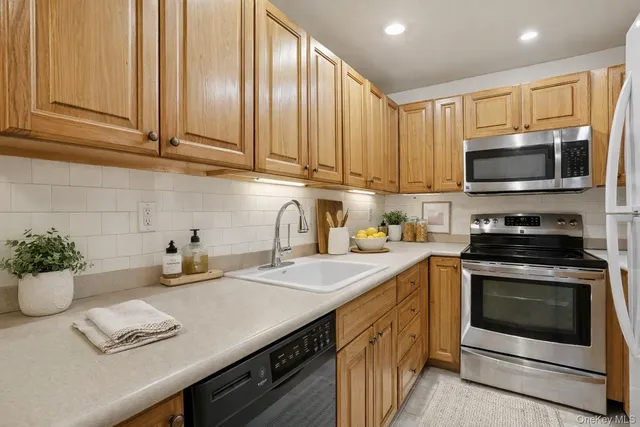 a kitchen with stainless steel appliances a stove microwave and sink