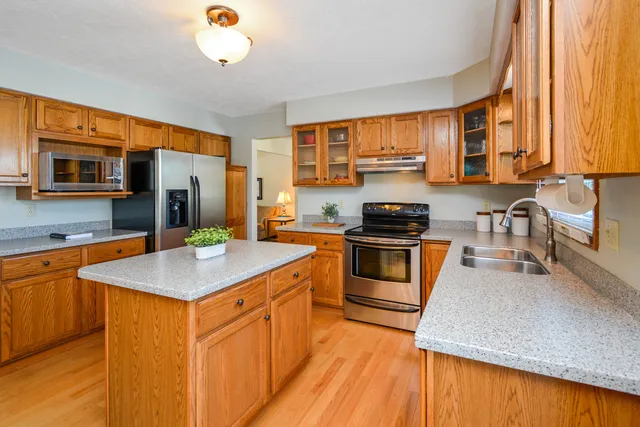 a kitchen with stainless steel appliances granite countertop a sink stove and cabinets