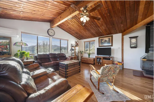 a living room with furniture a flat screen tv and wooden floor