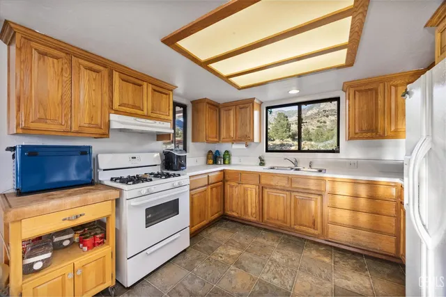 a kitchen with stainless steel appliances granite countertop a stove sink and cabinets