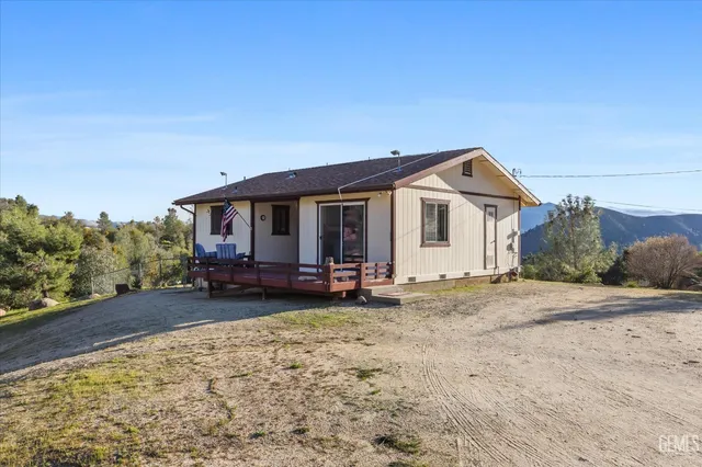 a front view of a house with a garden and trees