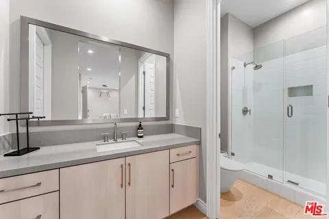 a kitchen with stainless steel appliances granite countertop a sink and a living room view