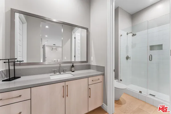 a kitchen with stainless steel appliances granite countertop a sink and a living room view
