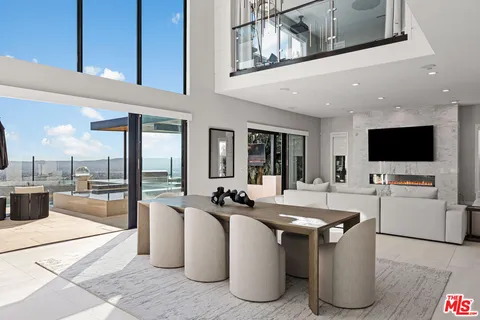 a living room with furniture white walls and kitchen view