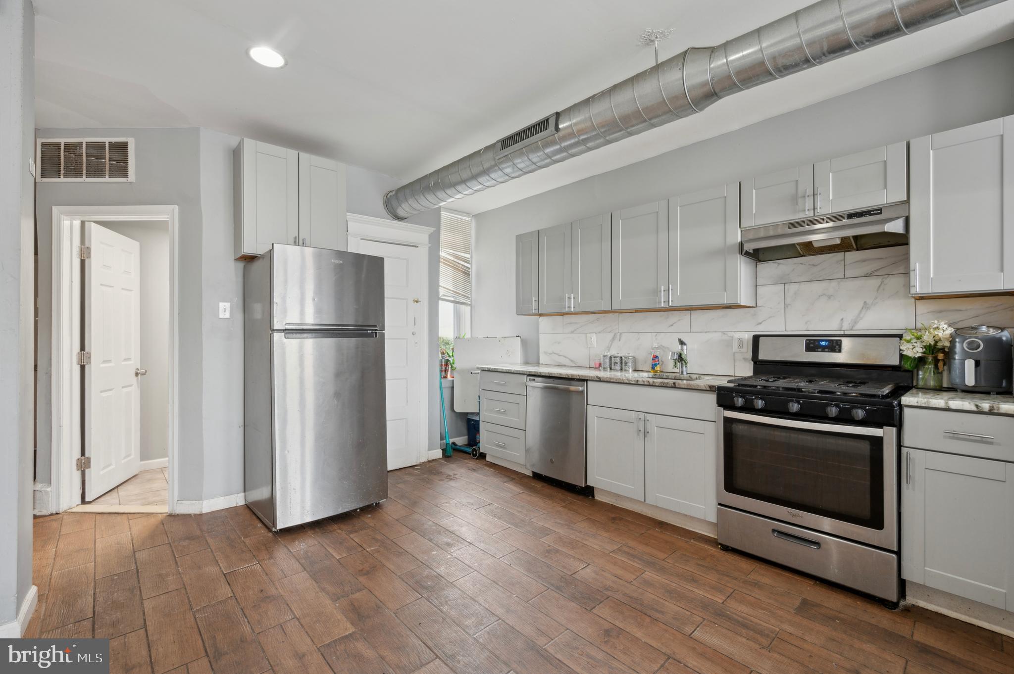 3236 West Berks Street Philadelphia, PA 19121 - Photo 24 of 35 a kitchen with a refrigerator stove and wooden cabinets