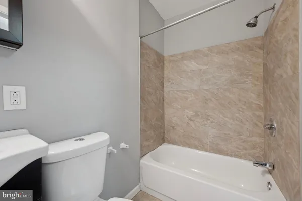 a white bath tub sitting next to a white toilet and a shower