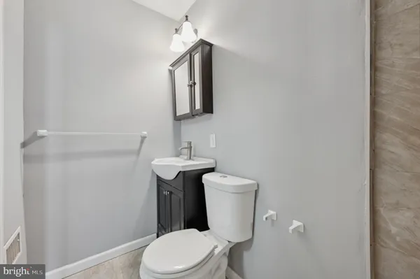 a white toilet sitting next to a bathroom sink
