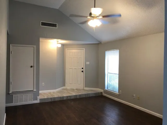 an empty room with wooden floor and window