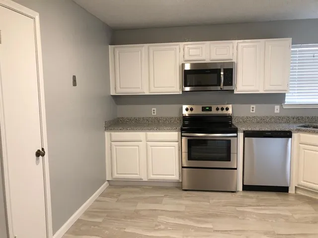 a kitchen with granite countertop a stove and a microwave