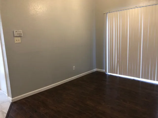 a view of an empty room with wooden floor