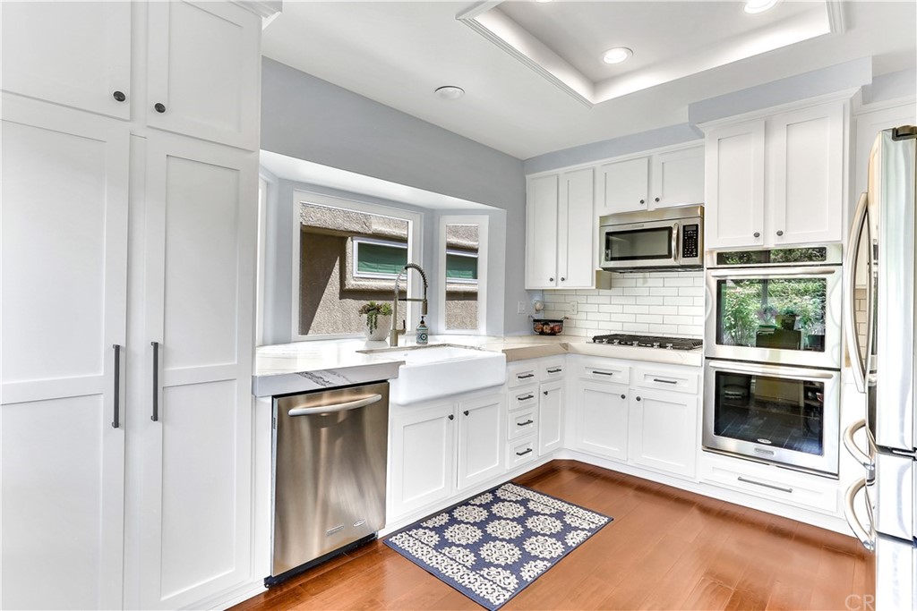 a kitchen with stainless steel appliances granite countertop a stove and white cabinets