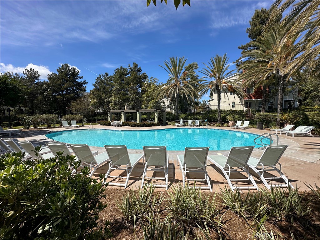 47 Bedstraw Loop Ladera Ranch, CA 92694 - Photo 40 of 44 a view of a swimming pool with lawn chairs under an umbrella