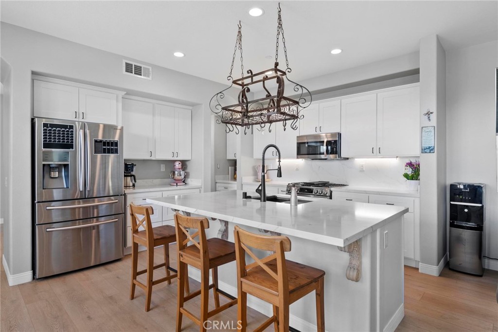 47 Bedstraw Loop Ladera Ranch, CA 92694 - Photo 6 of 44 a kitchen with kitchen island white cabinets and stainless steel appliances