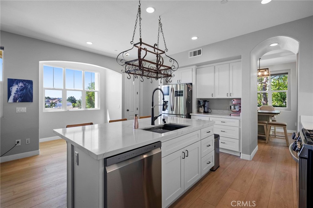 47 Bedstraw Loop Ladera Ranch, CA 92694 - Photo 7 of 44 a kitchen with white cabinets and center island